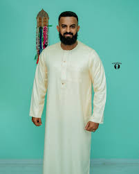 Man wearing an ivory formal kanzu, studio portrait
